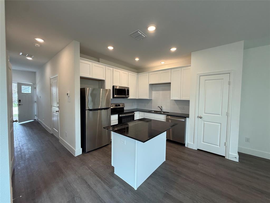 412 East 7th Street, Unit 2 Bonham, TX 75418 - Photo 3 of 20 a kitchen with kitchen island stainless steel appliances granite countertop a refrigerator and a sink