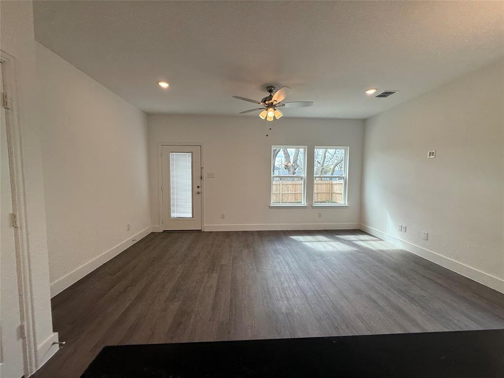 412 East 7th Street, Unit 2 Bonham, TX 75418 - Photo 4 of 20 an empty room with wooden floor and windows