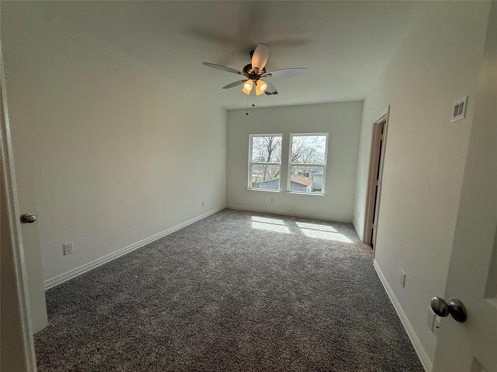 412 East 7th Street, Unit 2 Bonham, TX 75418 - Photo 10 of 20 an empty room with windows and ceiling fan