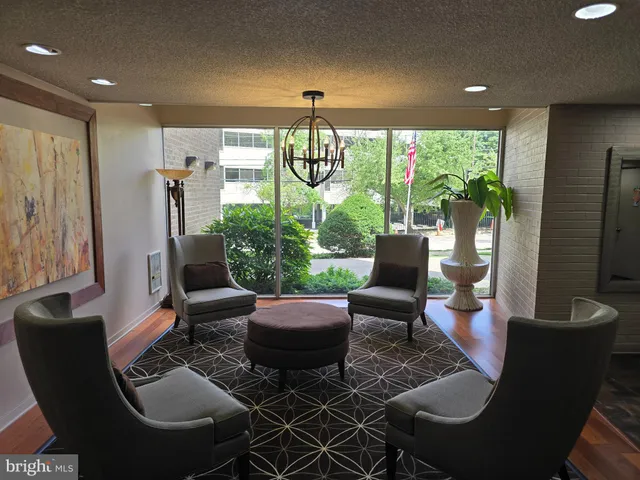a living room with furniture a flat screen tv and a floor to ceiling window