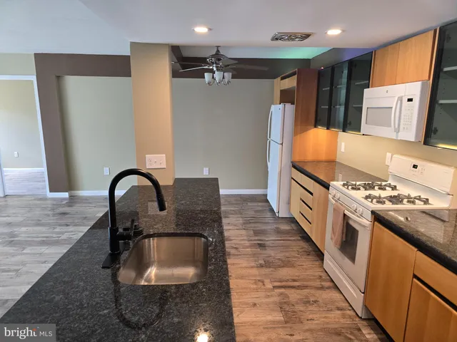 a kitchen with stainless steel appliances granite countertop a sink a stove and a refrigerator