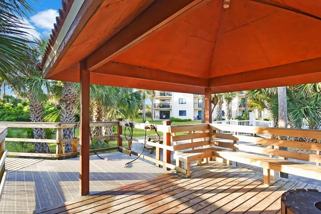 a view of a patio with table and chairs under an umbrella