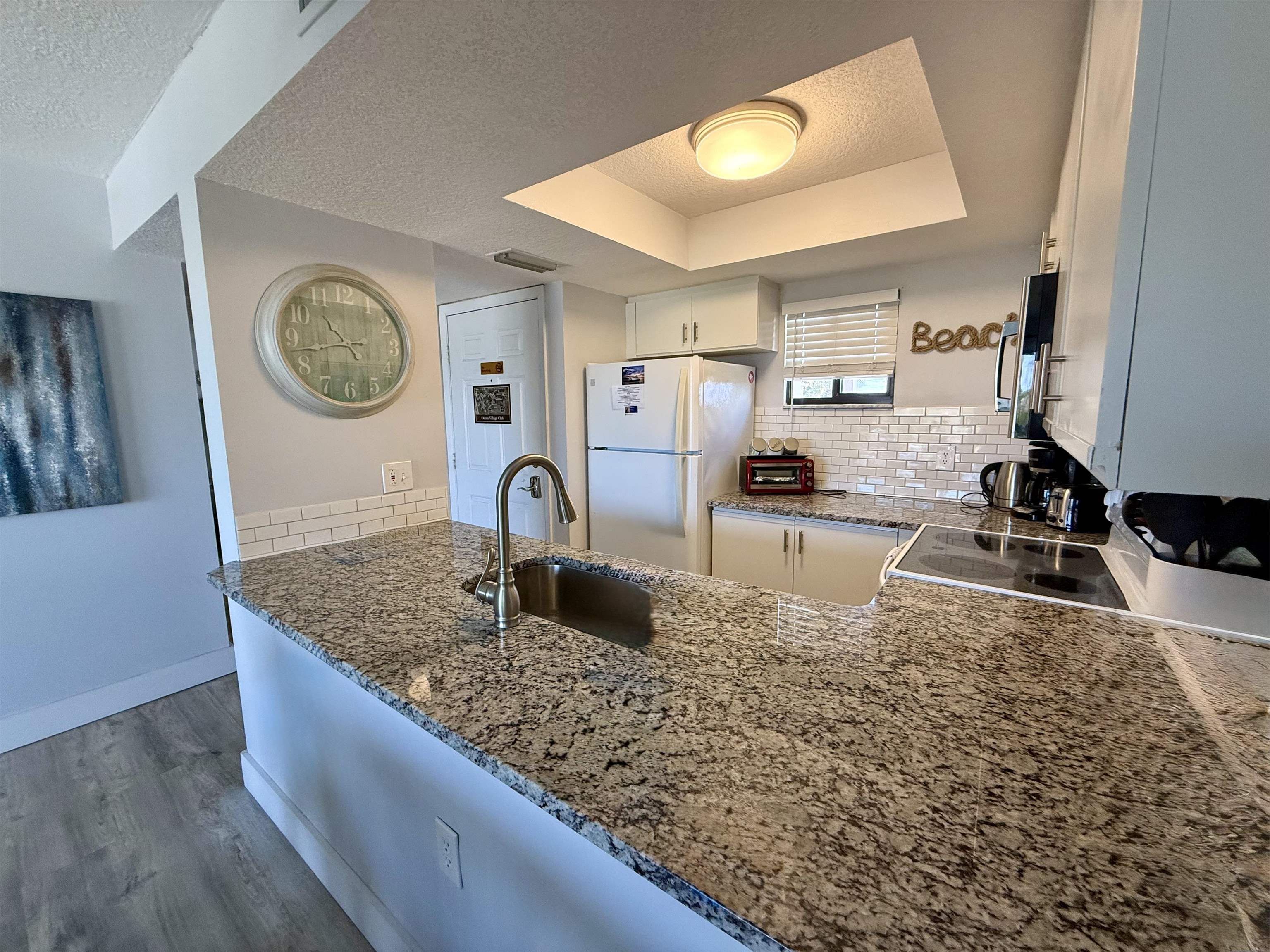 4250 A1A South, Unit M 31 St. Augustine, FL 32080 - Photo 3 of 21 a kitchen with kitchen island granite countertop a sink a stove and cabinets