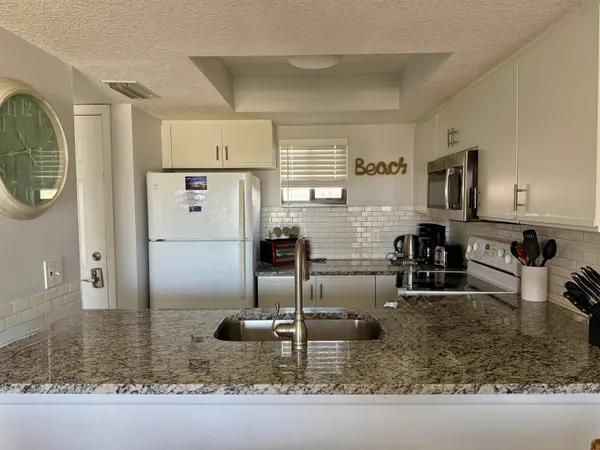 a kitchen with stainless steel appliances granite countertop a sink refrigerator and microwave