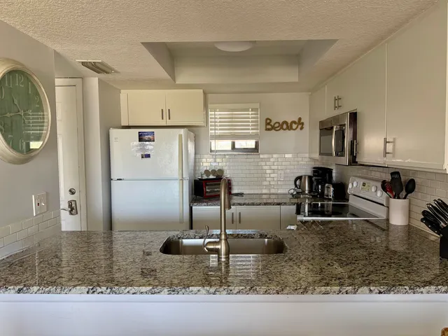 a kitchen with stainless steel appliances granite countertop a sink refrigerator and microwave