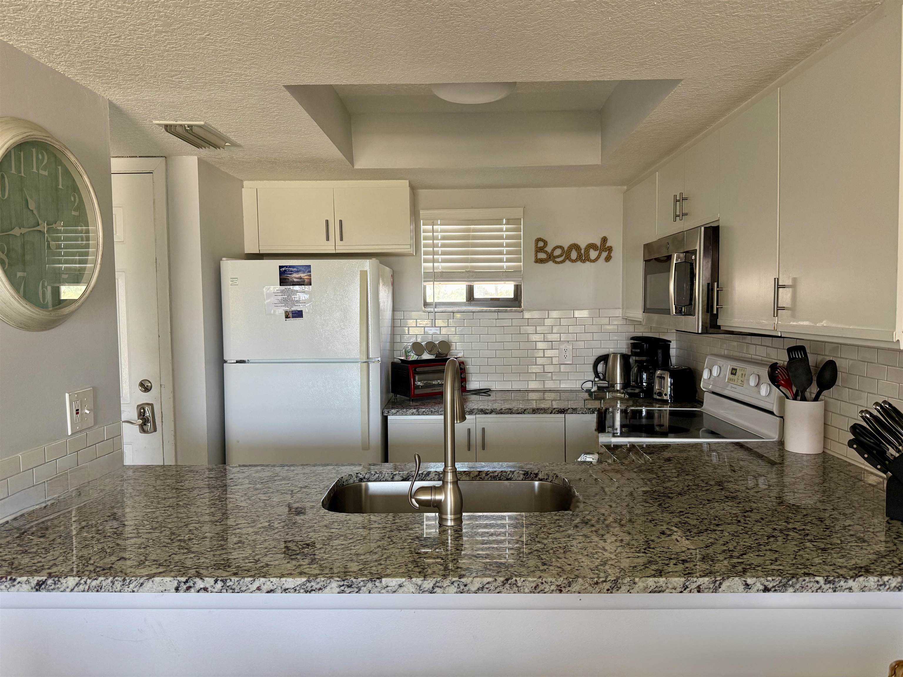 4250 A1A South, Unit M 31 St. Augustine, FL 32080 - Photo 4 of 21 a kitchen with stainless steel appliances granite countertop a sink refrigerator and microwave