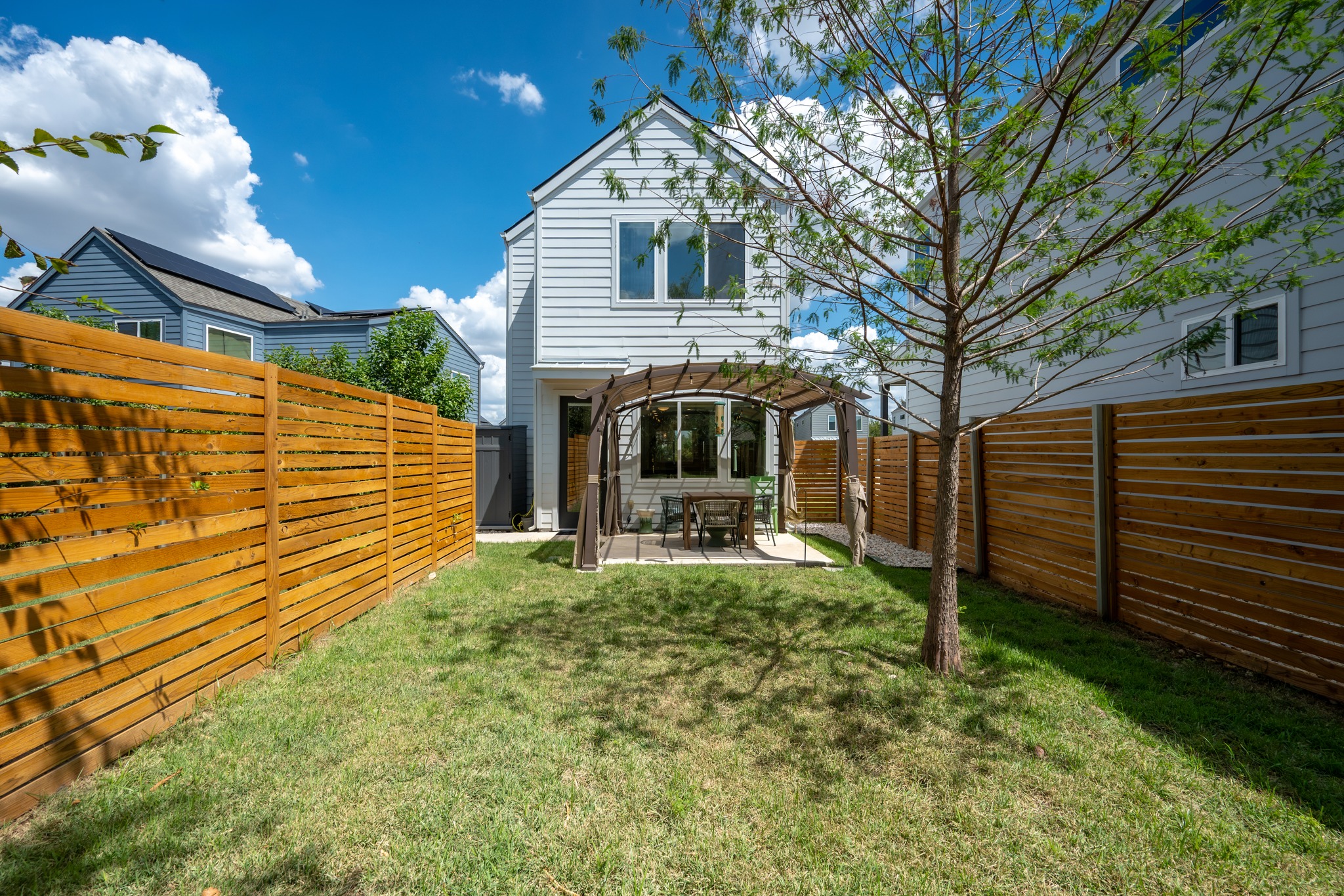 1190 Sarabeth Way Austin, TX 78721 - Photo 21 of 22 A fenced lawn leads to a private patio sheltered by a classic canopy covered curved pergola.