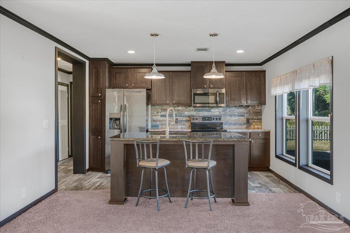 7789 Trinity Baptist Church Road Milton, FL 32570 - Photo 13 of 39 a kitchen with kitchen island granite countertop wooden cabinets and refrigerator
