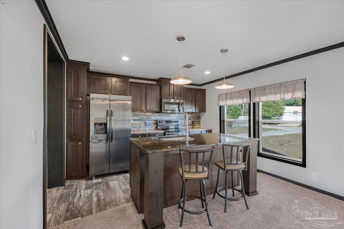 7789 Trinity Baptist Church Road Milton, FL 32570 - Photo 14 of 39 a kitchen with kitchen island a refrigerator and a table