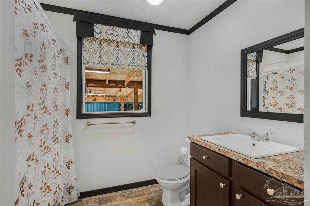 7789 Trinity Baptist Church Road Milton, FL 32570 - Photo 27 of 39 a bathroom with a granite countertop sink mirror vanity and toilet