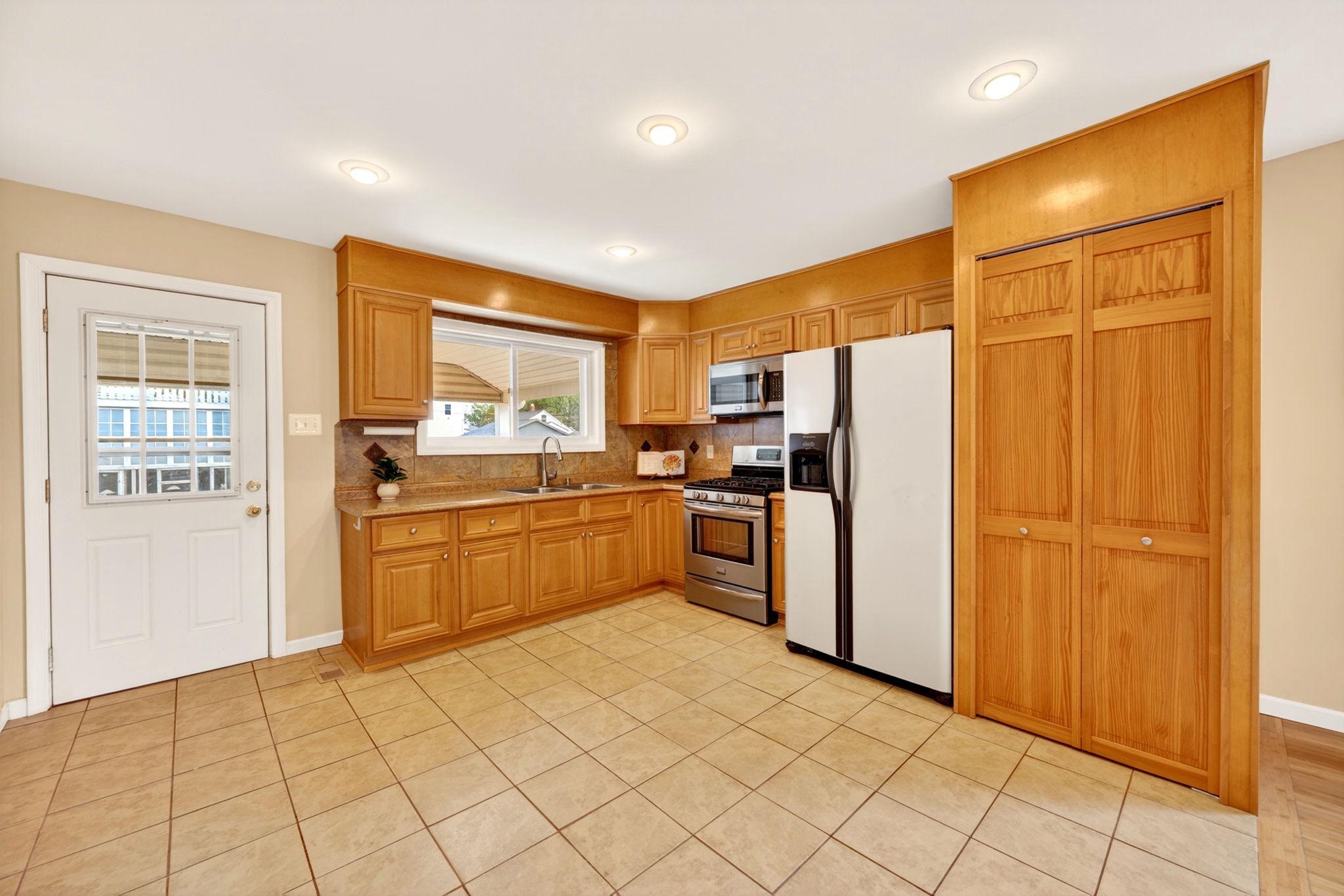 206 South Woodwell Road Baltimore, MD 21222 - Photo 12 of 46 a kitchen with stainless steel appliances a refrigerator and a stove top oven