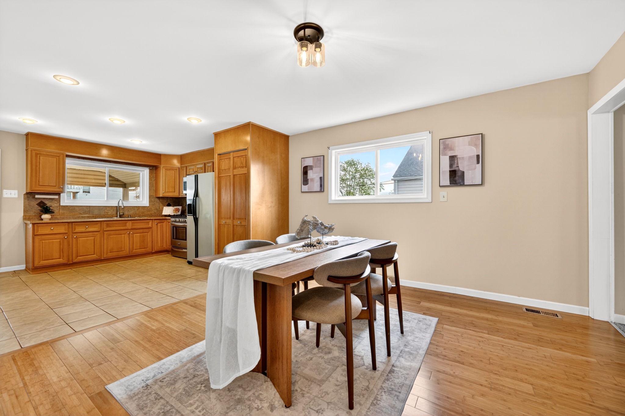 206 South Woodwell Road Baltimore, MD 21222 - Photo 14 of 46 a kitchen with stainless steel appliances granite countertop a refrigerator a stove a sink a dining table and chairs with wooden floor