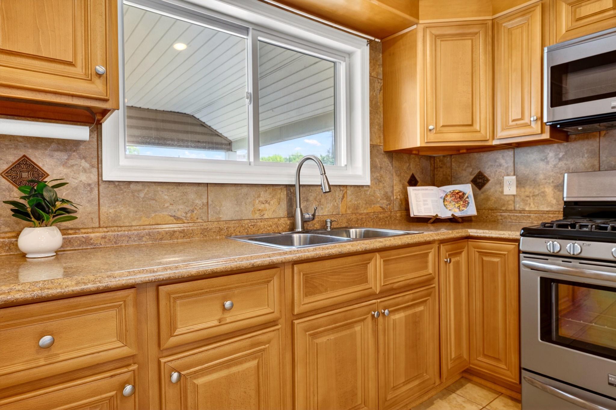 206 South Woodwell Road Baltimore, MD 21222 - Photo 9 of 46 a kitchen with stainless steel appliances granite countertop a sink a stove and a microwave