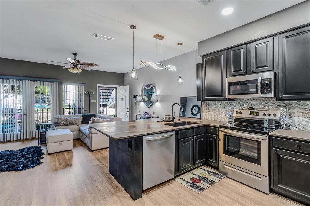 1933 Island Circle, Unit B106 Tool, TX 75143 - Photo 11 of 12 a kitchen with stainless steel appliances granite countertop a stove top oven a sink dishwasher a dining table and chairs with wooden floor