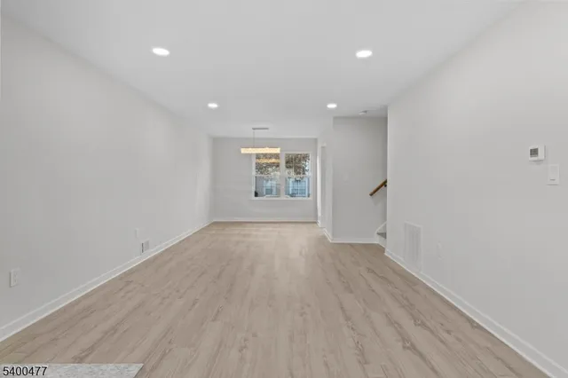 a view of a chandelier in big room with wooden floor