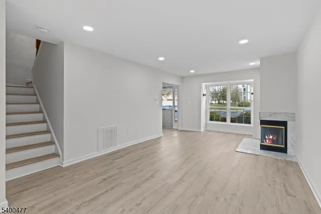 a view of a livingroom with wooden floor and a fireplace