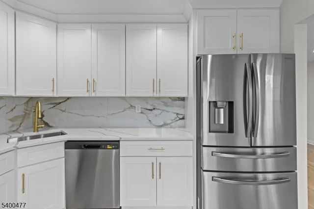 a kitchen with appliances a refrigerator and a sink