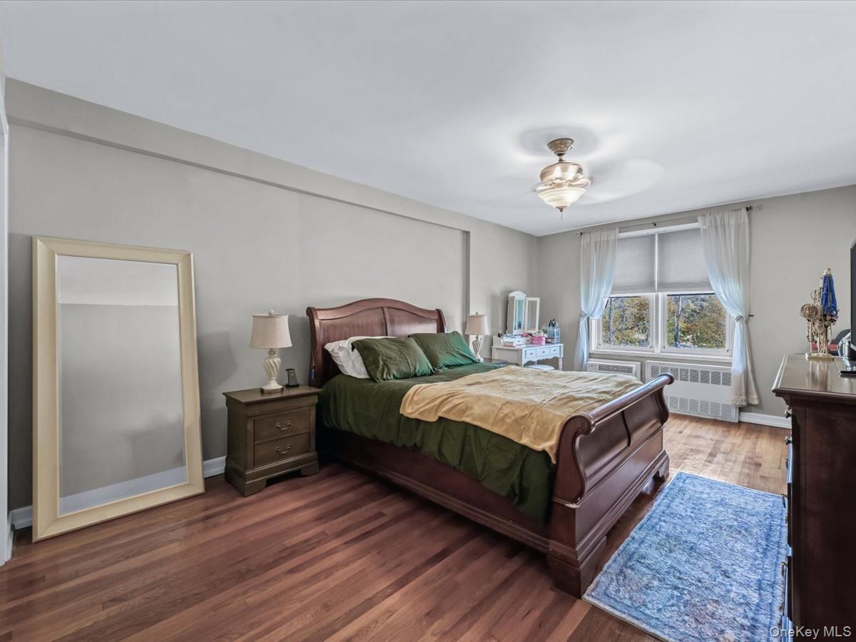 241-20 Northern Boulevard, Unit 6M Queens, NY 11362 - Photo 6 of 18 a bedroom with a bed and wooden floor