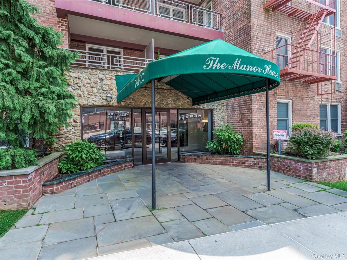 241-20 Northern Boulevard, Unit 6M Queens, NY 11362 - Photo 10 of 18 a view of a cafe with a table and chairs under an umbrella
