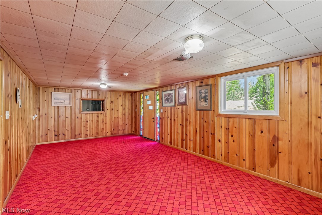 2060 6th Street Southwest Akron, OH 44314 - Photo 28 of 46 Lower level family room with knotty pine walls and carpet flooring