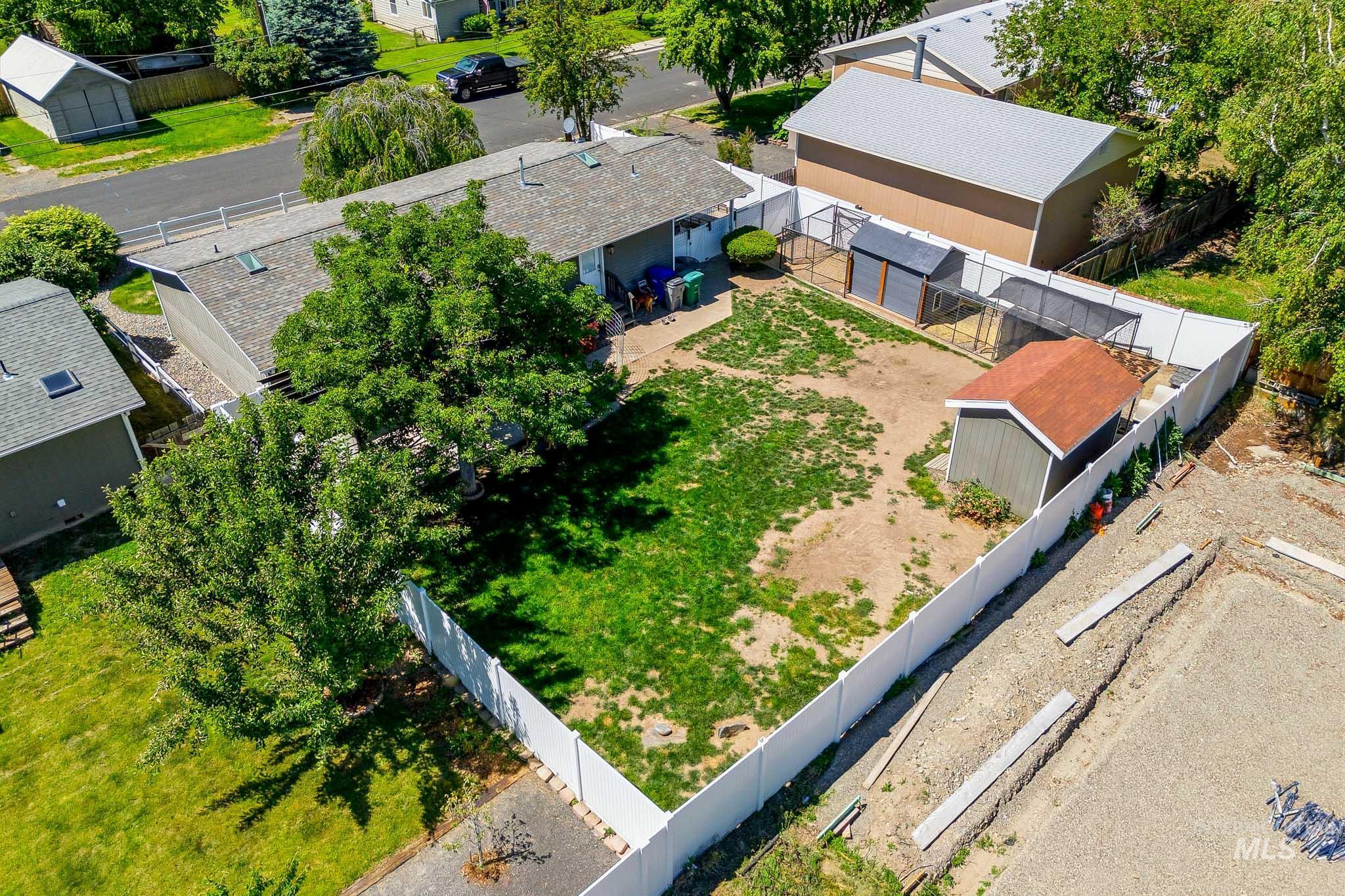 3715 18th Street Lewiston, ID 83501 - Photo 23 of 30 Spacious backyard featuring a section of manicured lawn, mature trees, and a white perimeter fence