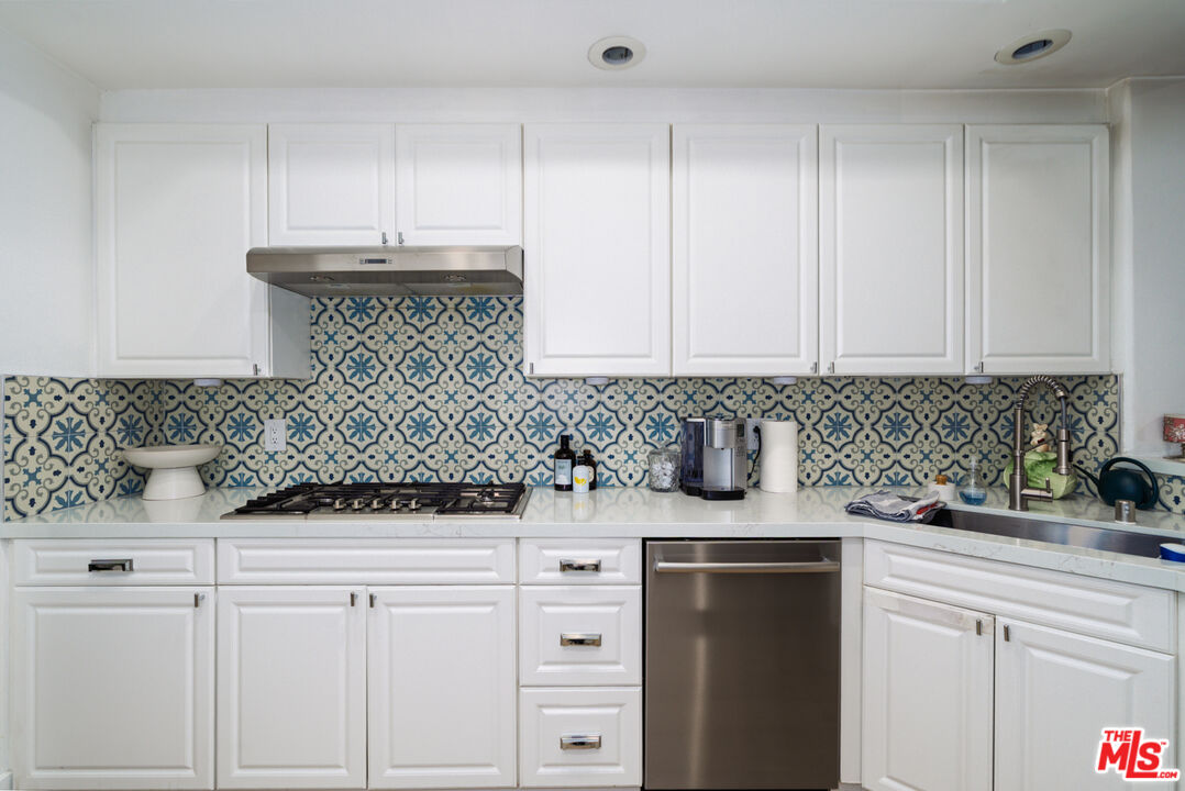 11740 Sunset Boulevard, Unit 14 Los Angeles, CA 90049 - Photo 12 of 44 a kitchen with stainless steel appliances white cabinets and a sink