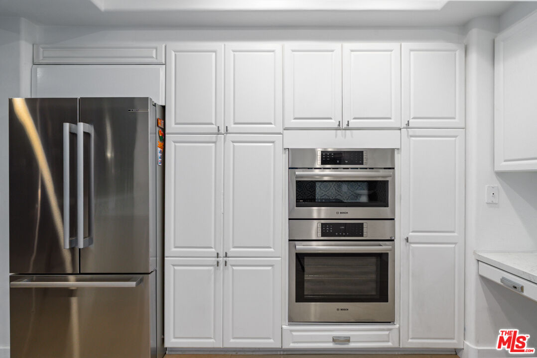 11740 Sunset Boulevard, Unit 14 Los Angeles, CA 90049 - Photo 13 of 44 a kitchen with cabinets and stainless steel appliances