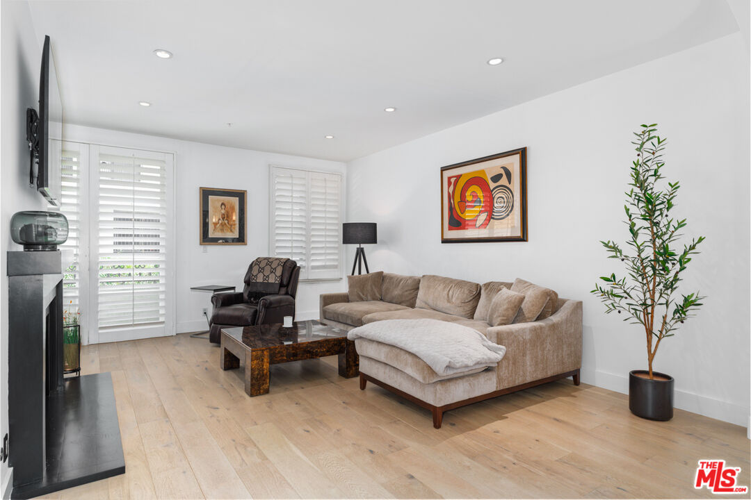 11740 Sunset Boulevard, Unit 14 Los Angeles, CA 90049 - Photo 21 of 44 a living room with furniture and a potted plant