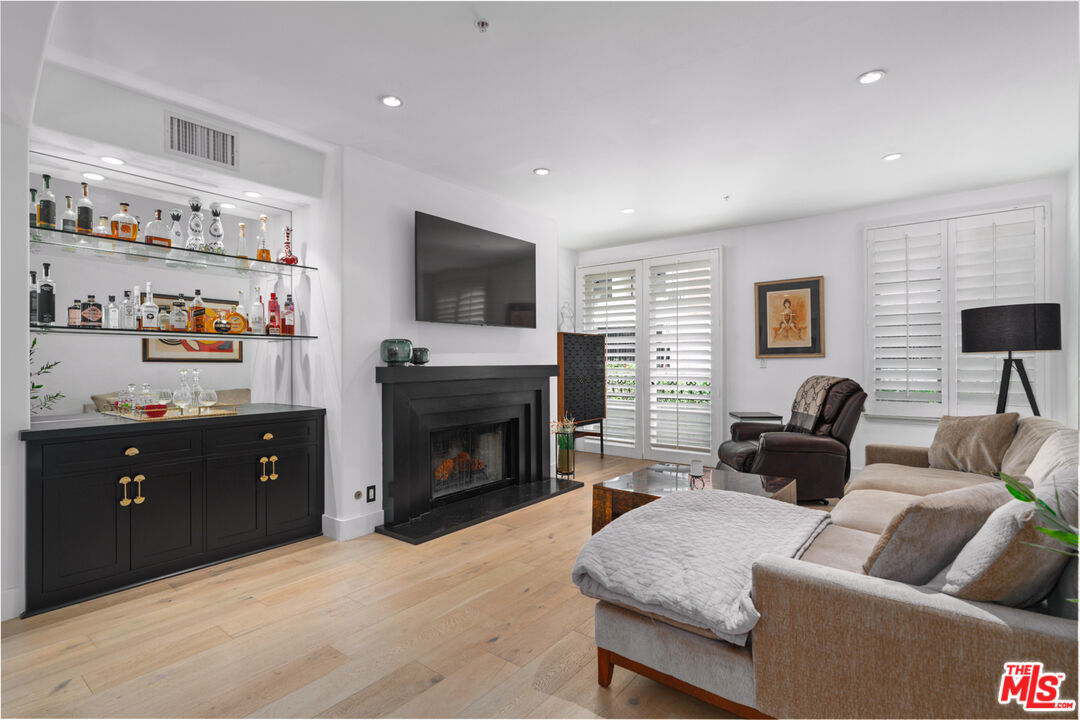 11740 Sunset Boulevard, Unit 14 Los Angeles, CA 90049 - Photo 22 of 44 a living room with furniture and a flat screen tv