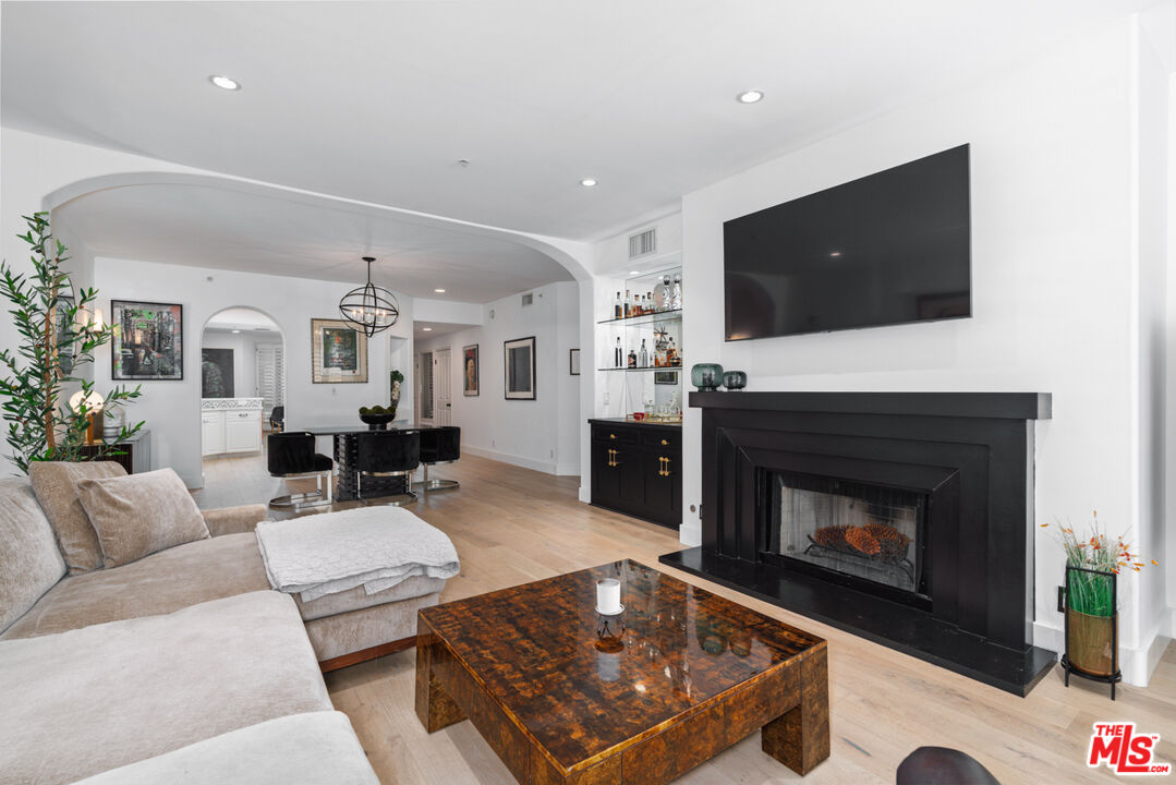 11740 Sunset Boulevard, Unit 14 Los Angeles, CA 90049 - Photo 25 of 44 a living room with furniture a flat screen tv and a fireplace