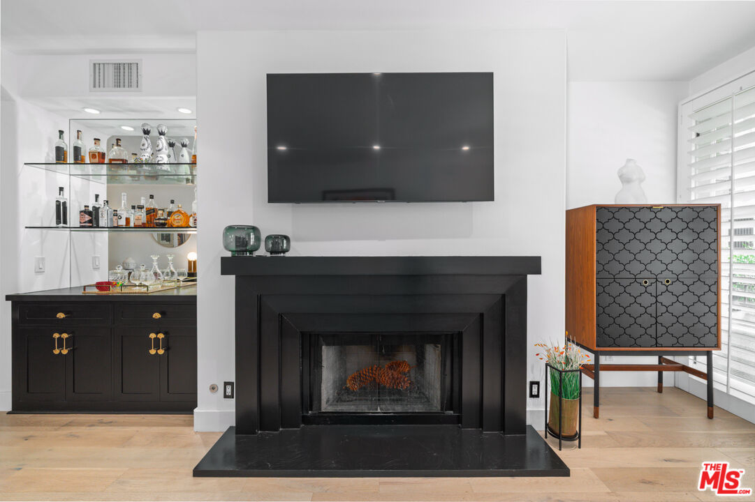 11740 Sunset Boulevard, Unit 14 Los Angeles, CA 90049 - Photo 26 of 44 a living room with a fireplace and a flat screen tv
