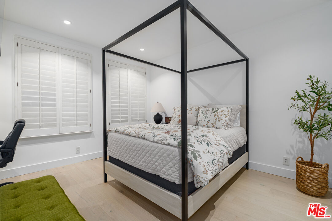 11740 Sunset Boulevard, Unit 14 Los Angeles, CA 90049 - Photo 29 of 44 a bed sitting in a spacious bedroom next to a window