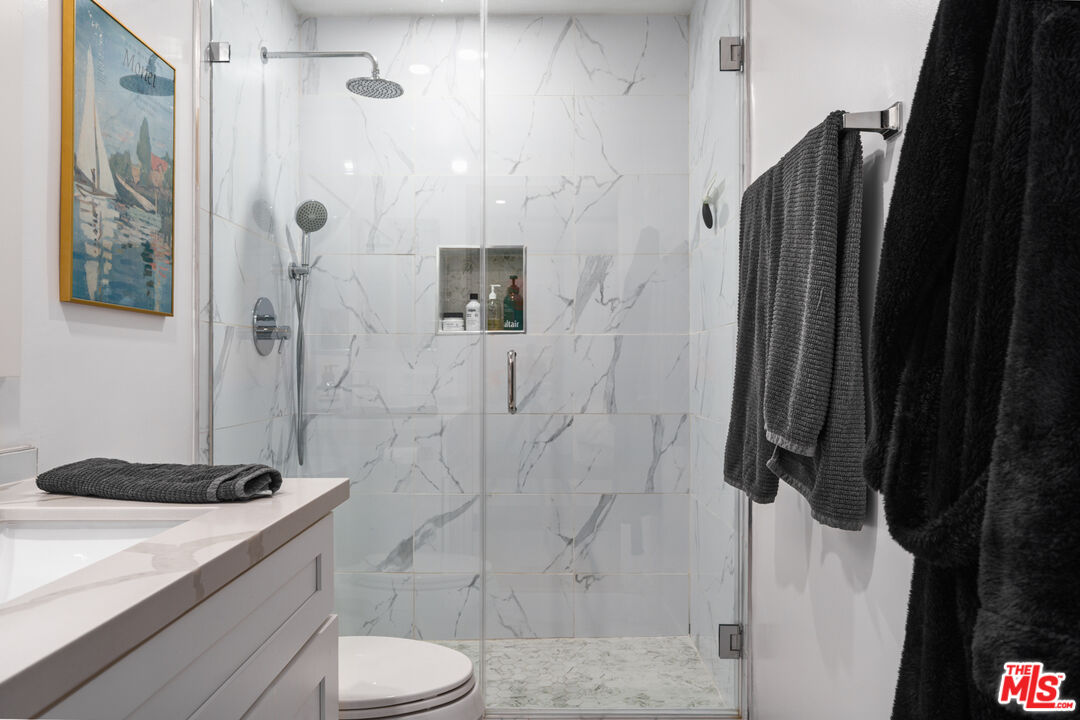 11740 Sunset Boulevard, Unit 14 Los Angeles, CA 90049 - Photo 36 of 44 a bathroom with a granite countertop sink a toilet and shower
