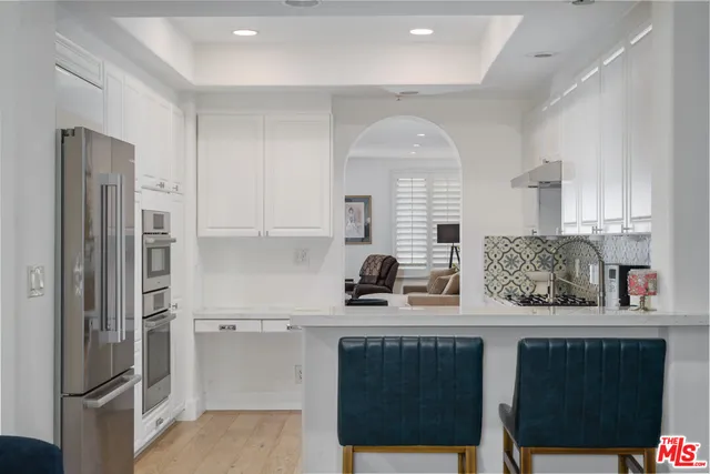 a view of a hallway with wooden floor and a living room