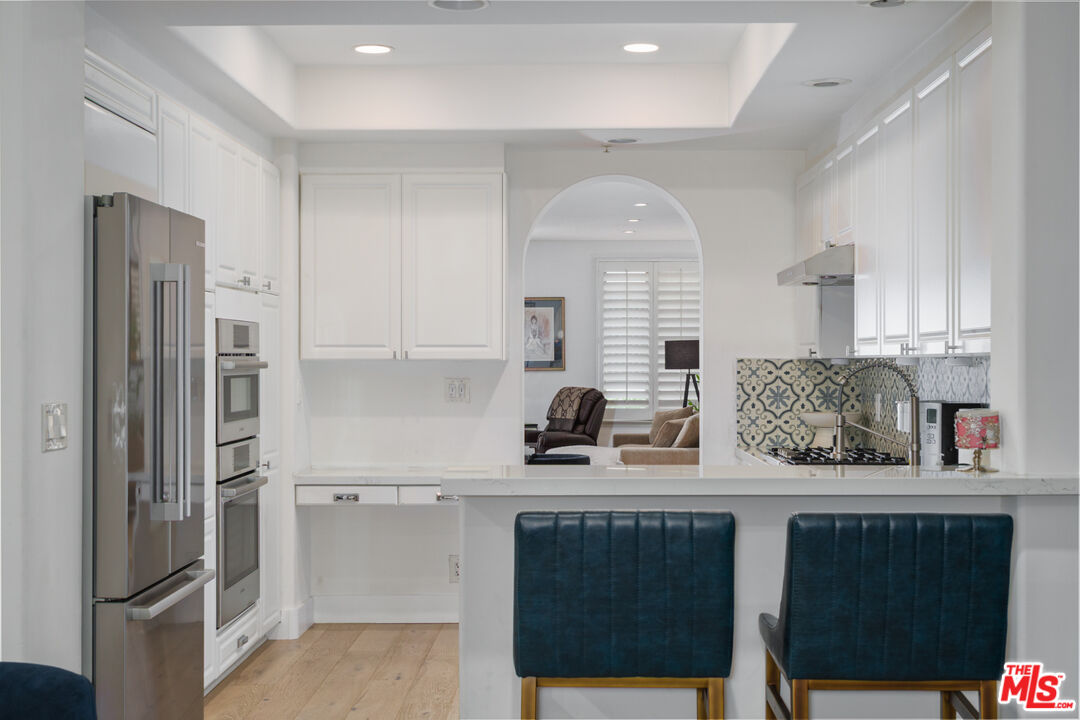 11740 Sunset Boulevard, Unit 14 Los Angeles, CA 90049 - Photo 9 of 44 a kitchen with stainless steel appliances granite countertop a refrigerator sink and cabinets