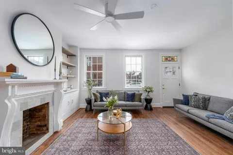 a living room with furniture a fireplace and a large window