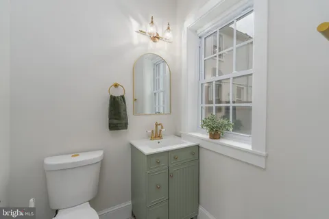 a bathroom with a toilet a sink and a mirror