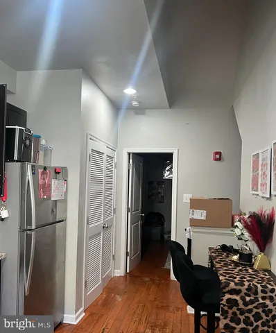 a living room with furniture and a refrigerator