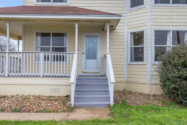 a view of a house with a small yard and wooden floor and fence