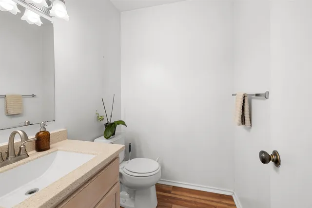 a bathroom with a sink vanity mirror and toilet