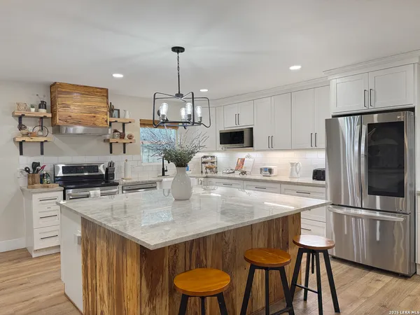 a kitchen with white cabinets and a window
