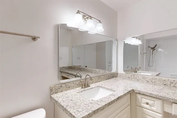 a bathroom with a granite countertop sink and a mirror