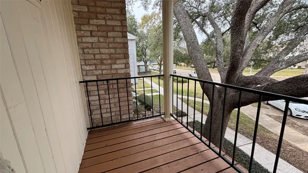 a view of balcony with wooden floor and fence and trees