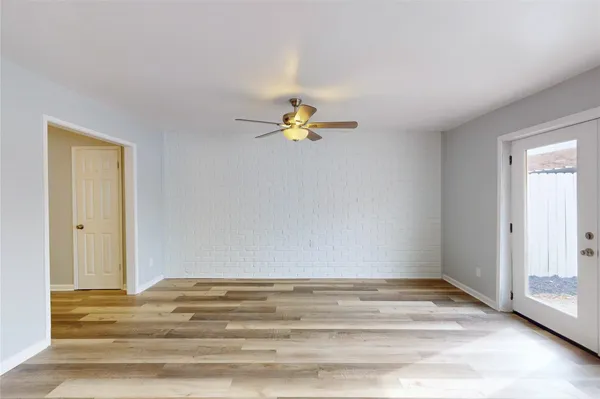 a view of a room with wooden floor and ceiling fan