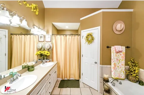 a bathroom with a granite countertop tub sink and mirror