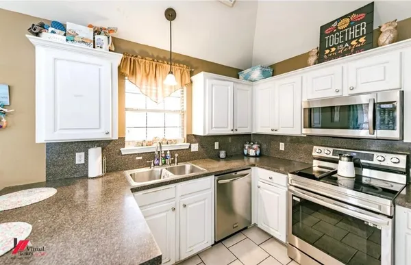 a kitchen with stainless steel appliances granite countertop a sink a stove and cabinets