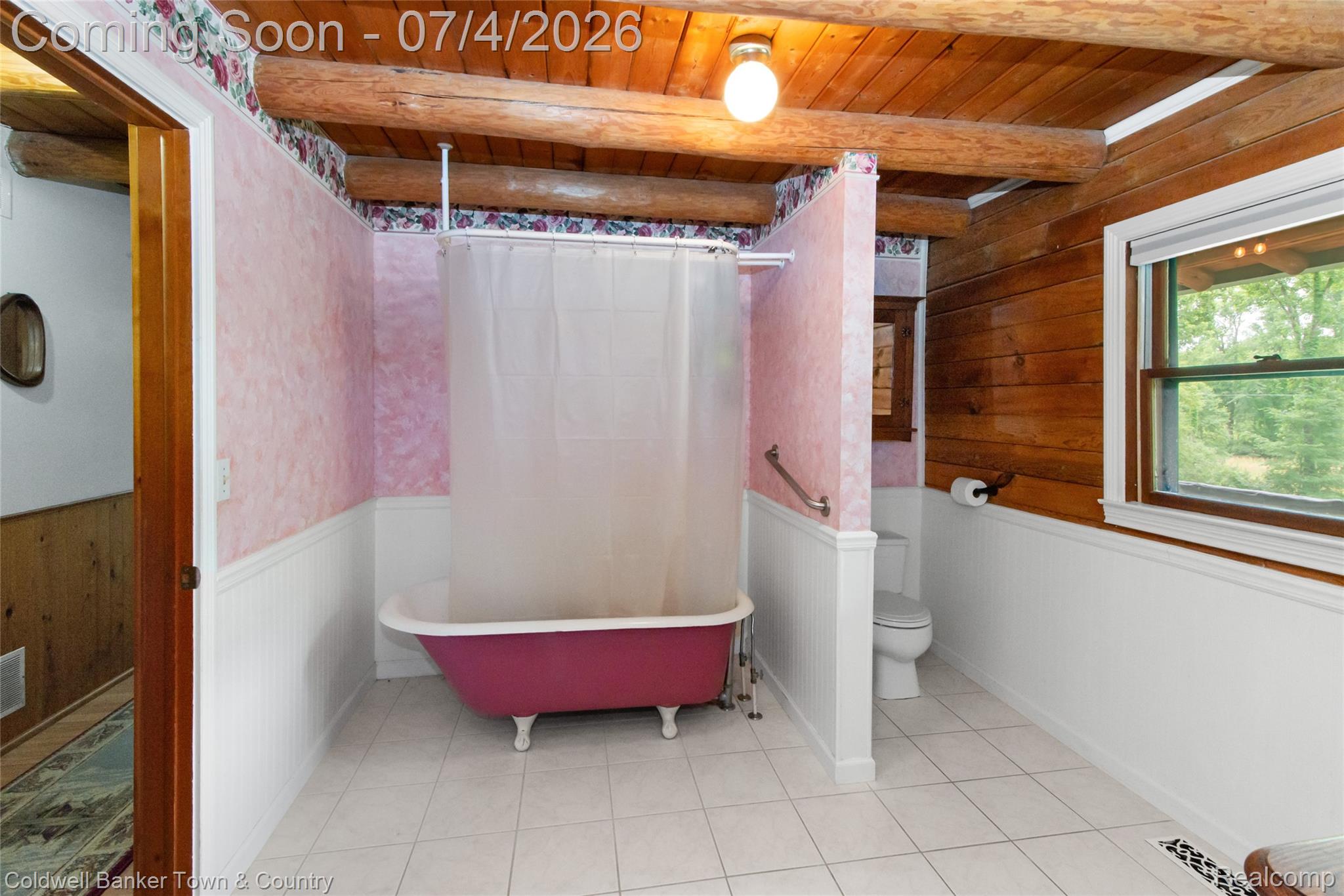 7335 Richardson Road Howell, MI 48843 - Photo 29 of 54 Bathroom featuring a clawfoot tub, white ceramic tile flooring, beadboard wainscoting, a window, and exposed wood ceiling beams