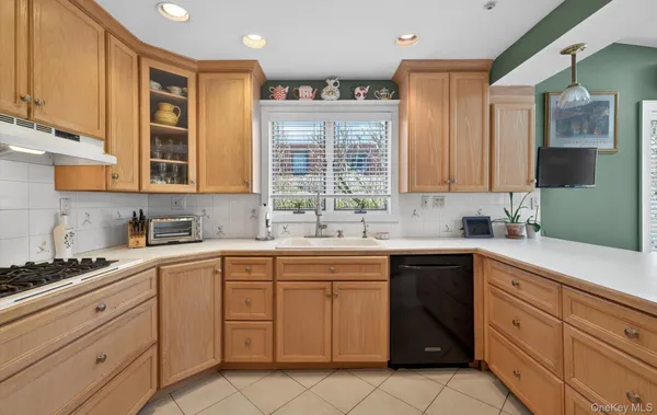 a kitchen with cabinets appliances a sink and a window