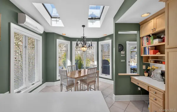 a room with stainless steel appliances wooden floor and chandelier