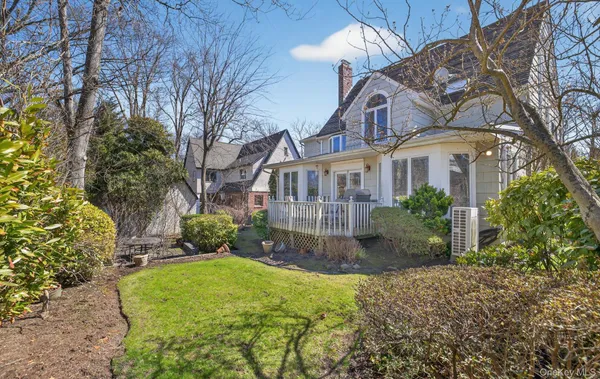 a view of a white house with a yard and plants
